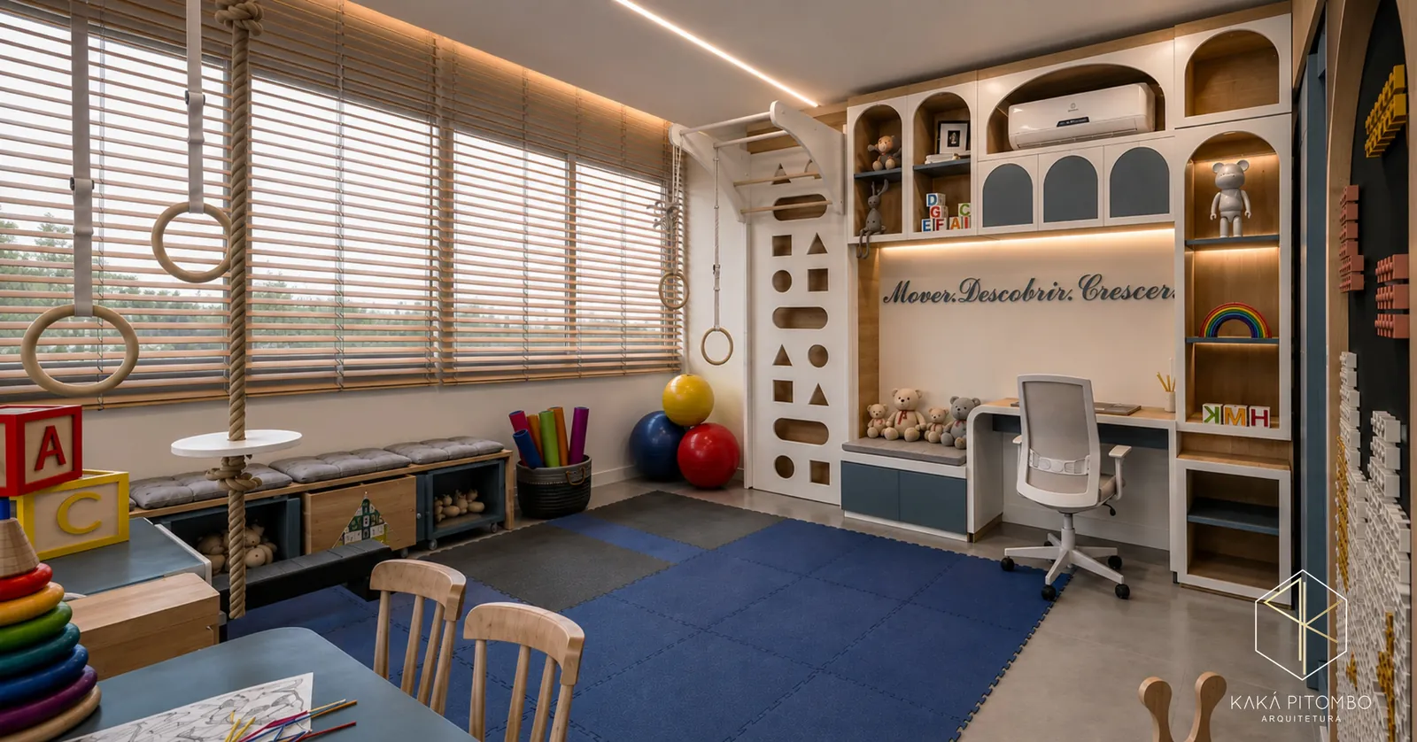 Sala de psicomotricidade infantil com tatame azul, argolas, nichos em arco e mesa de atendimento